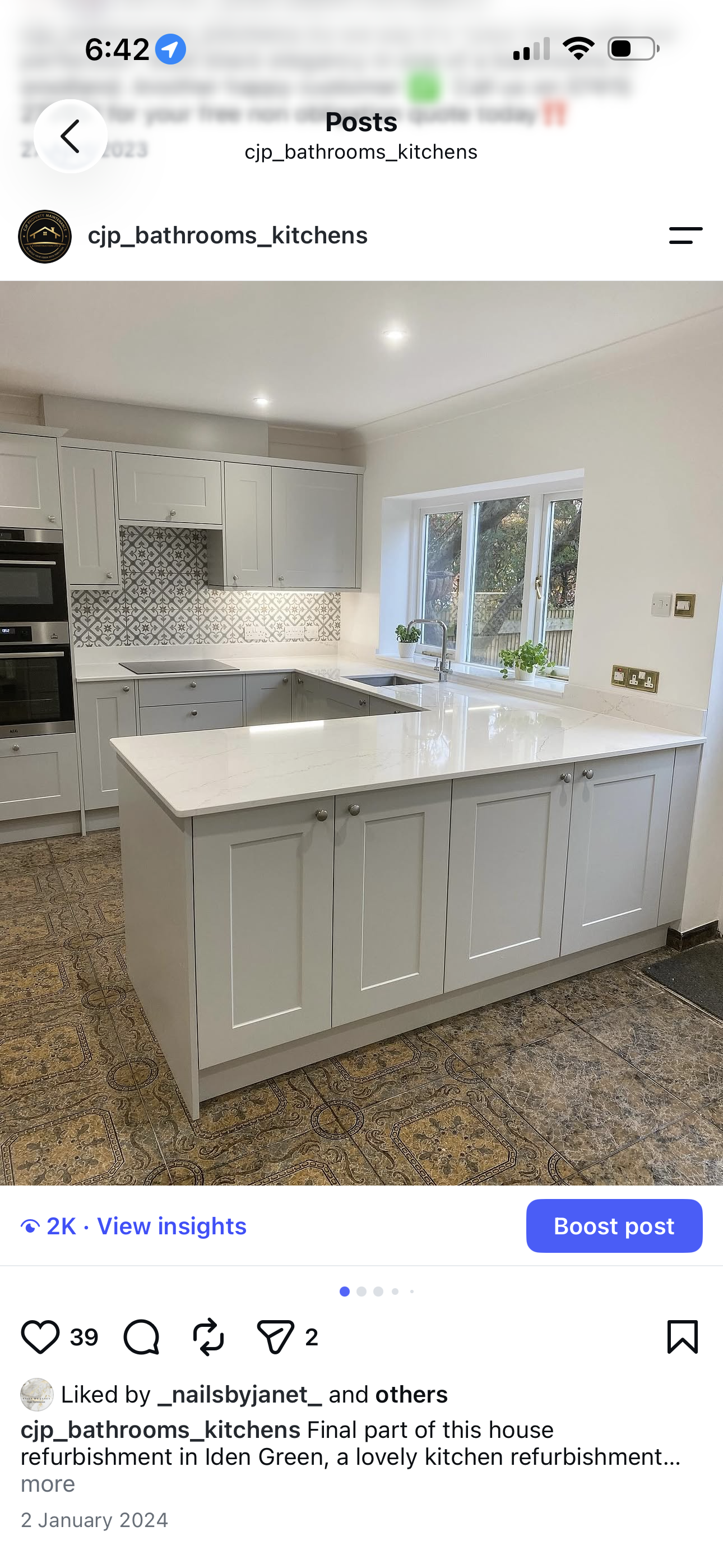 Grey shaker kitchen with white quartz island, patterned tile splashback and garden-view window
